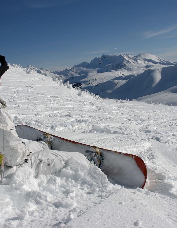 Enfant assis dans la neige avec sa luge